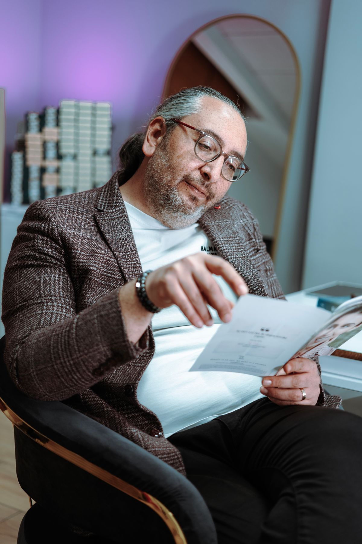 窓の近くのオフィスで書類を読むビジネスパーソン